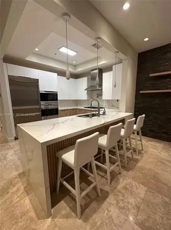 a kitchen with a dining table chairs stainless steel appliances and cabinets