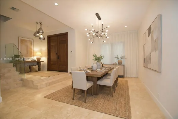 a dining room with wooden floor a chandelier a wooden table and chairs