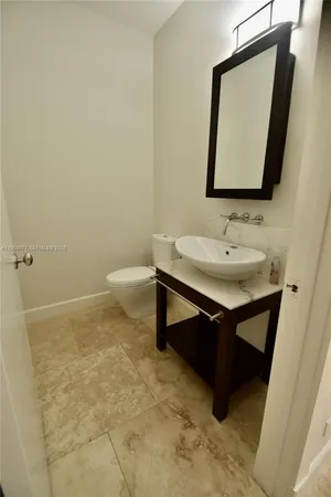 a bathroom with a sink toilet and mirror
