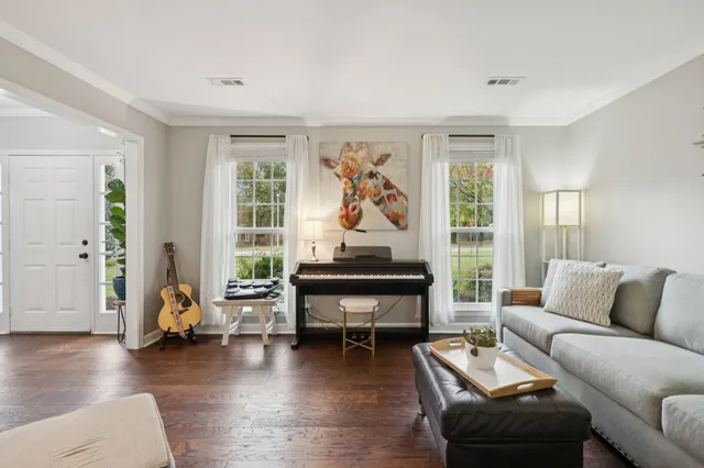 a living room with furniture a wooden floor and a large window