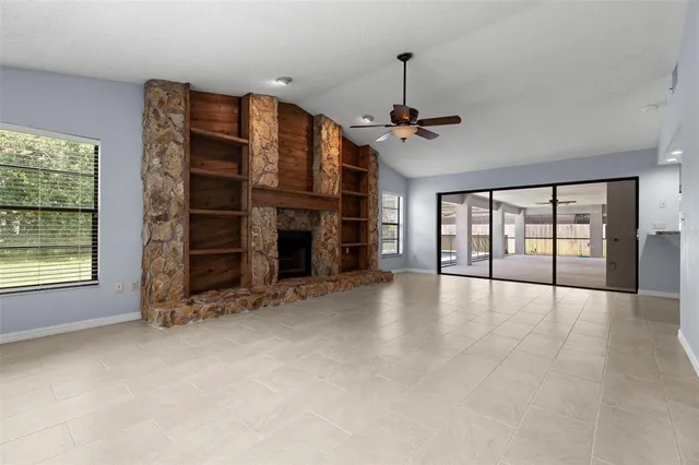 a view of an empty room with a fireplace and a window