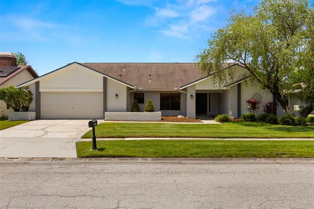 a front view of a house with a garden and trees