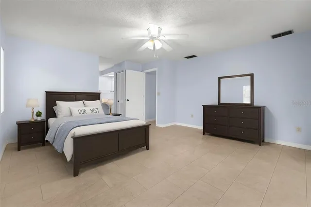 a view of an empty room with a ceiling fan and window