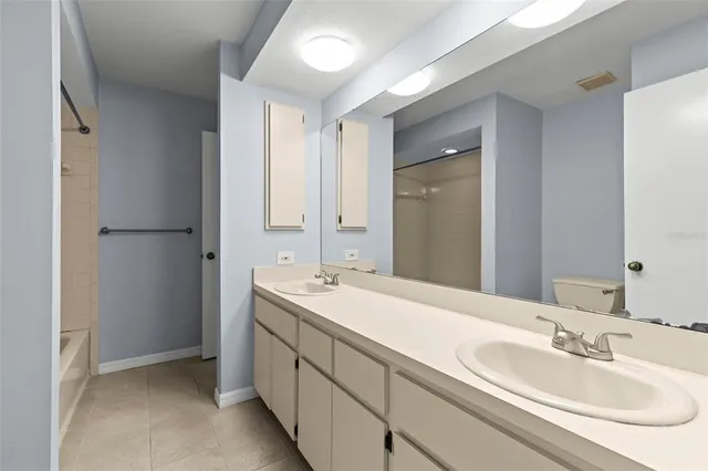 an empty room with chandelier fan and windows