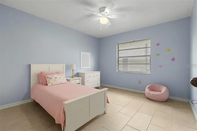 a bedroom with a bed dresser and a two windows