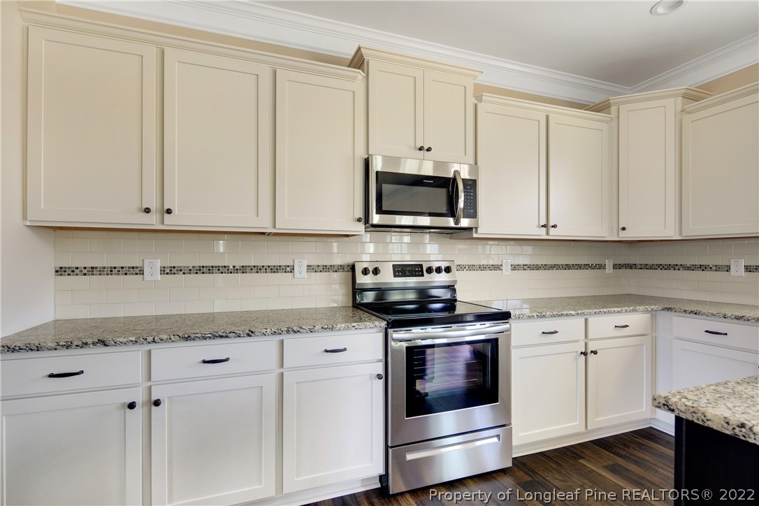 2605 Riddle Farm Hope Mills, NC 28348 - Photo 15 of 50 a kitchen with granite countertop white cabinets and stainless steel appliances