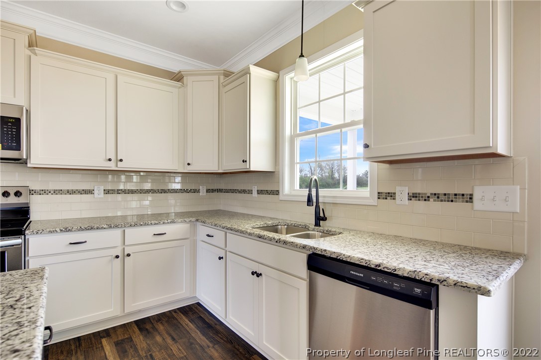 2605 Riddle Farm Hope Mills, NC 28348 - Photo 17 of 50 a kitchen with stainless steel appliances granite countertop a sink a stove and cabinets