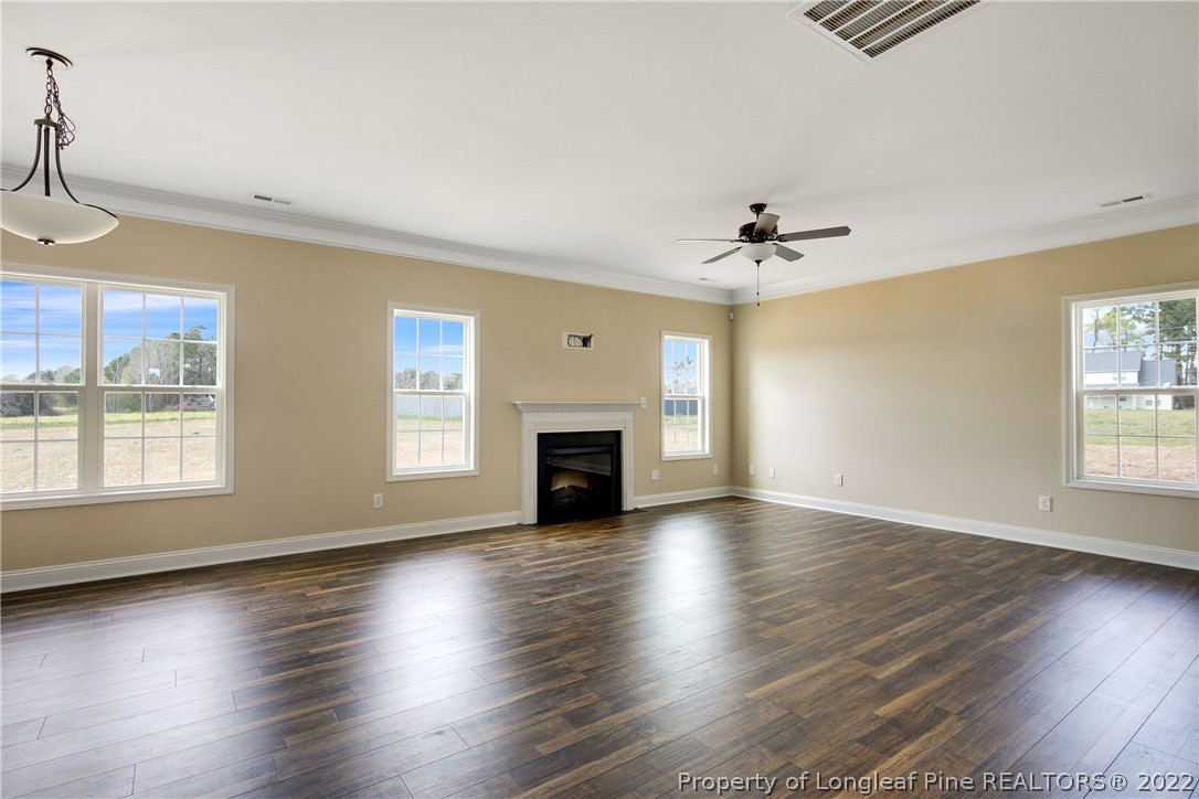 2605 Riddle Farm Hope Mills, NC 28348 - Photo 7 of 50 an empty room with wooden floor fireplace and windows