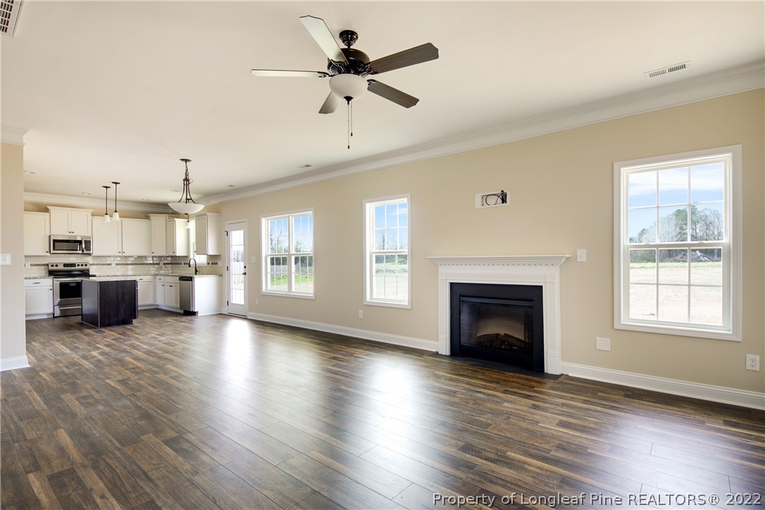 2605 Riddle Farm Hope Mills, NC 28348 - Photo 8 of 50 a view of a big room with wooden floor a fireplace and a kitchen