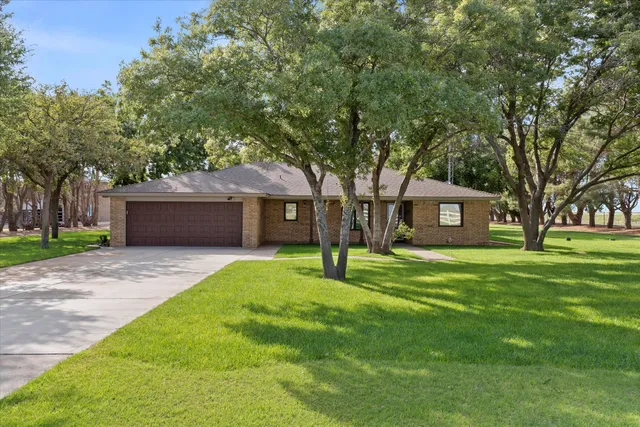 a front view of a house with a garden and trees
