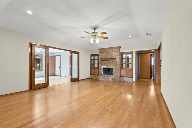 a view of an empty room with a window and a kitchen
