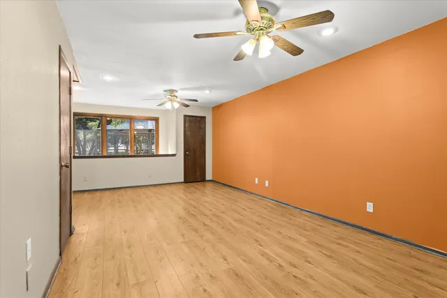a view of an empty room and chandelier fan