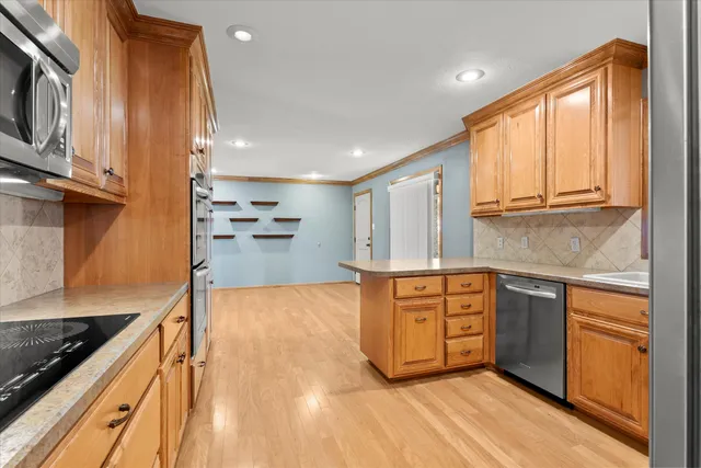 a kitchen with stainless steel appliances granite countertop a stove a sink and a refrigerator
