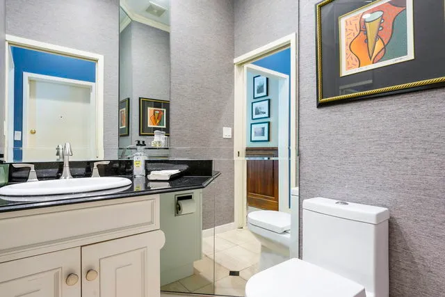 a bathroom with a toilet sink and mirror