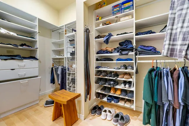 a view of walk in closet with clothes and shoes