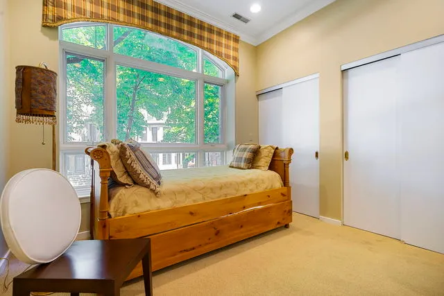 a bed sitting in a bedroom next to a window