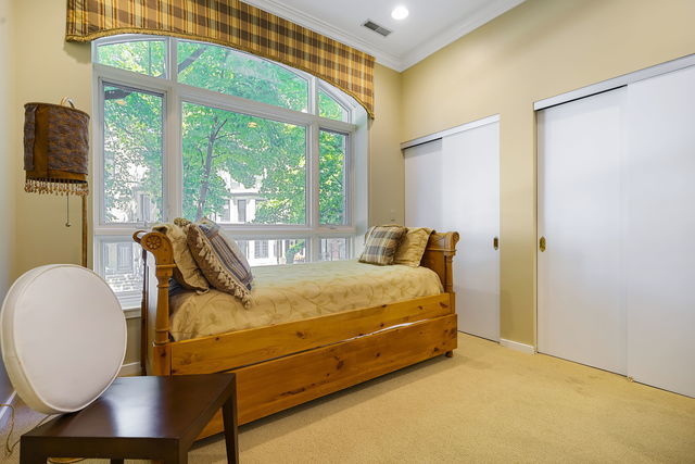 45 East Cedar Street, Unit 200 Chicago, IL 60611 - Photo 20 of 35 a bed sitting in a bedroom next to a window