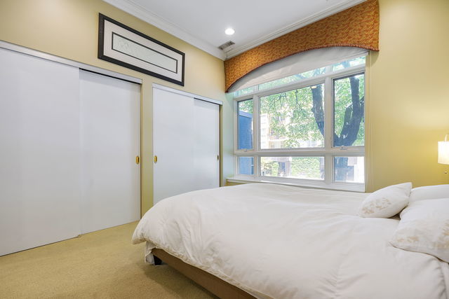 45 East Cedar Street, Unit 200 Chicago, IL 60611 - Photo 22 of 35 a bed sitting in a bedroom next to a window