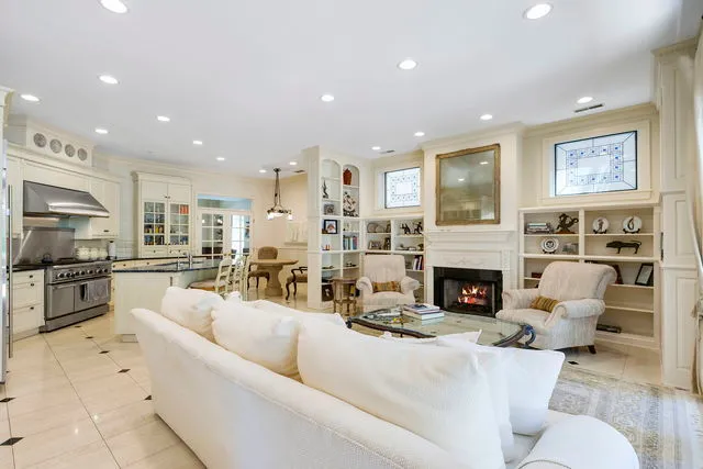 a living room with furniture a fireplace and a open kitchen view