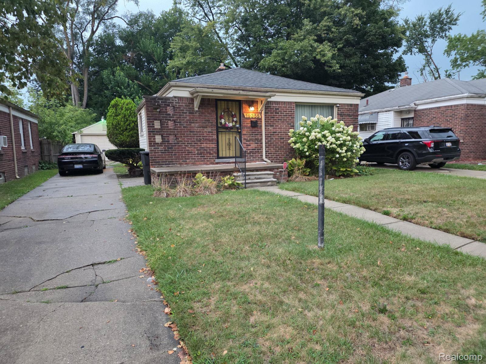 19355 Burt Road Detroit, MI 48219 - Photo 1 of 25 Brick exterior with stone accents, covered front porch, and mature landscaping