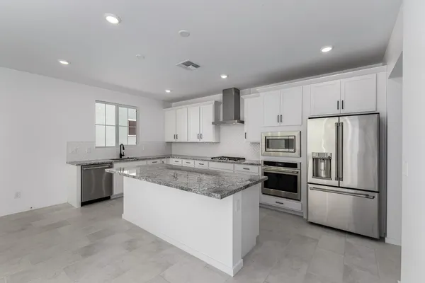 a kitchen with stainless steel appliances granite countertop a stove a refrigerator and a refrigerator