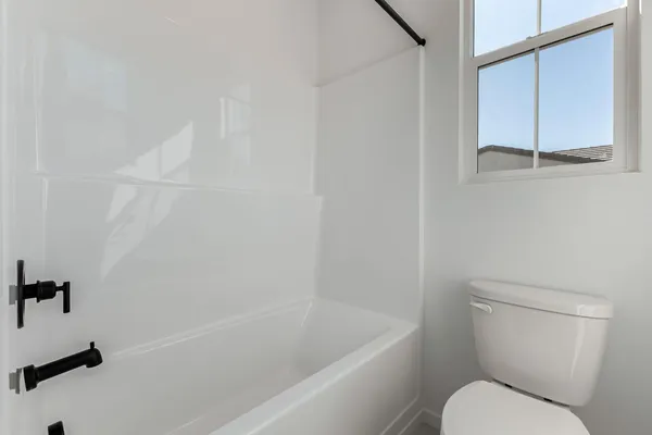 a white toilet sitting next to a bath tub