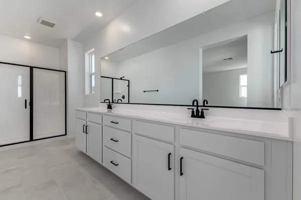 a bathroom with a double vanity sink and mirror