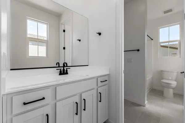 a bathroom with a sink a toilet and a window