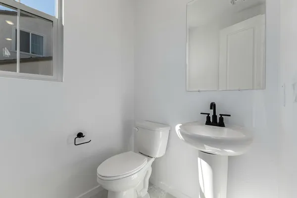 a bathroom with a toilet a sink and mirror