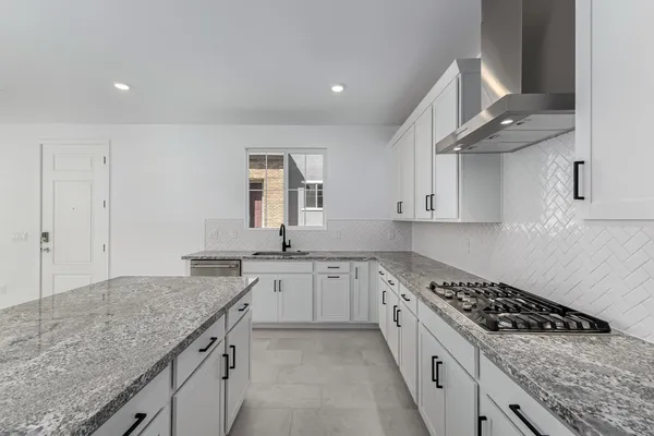a kitchen with granite countertop a sink stove and cabinets