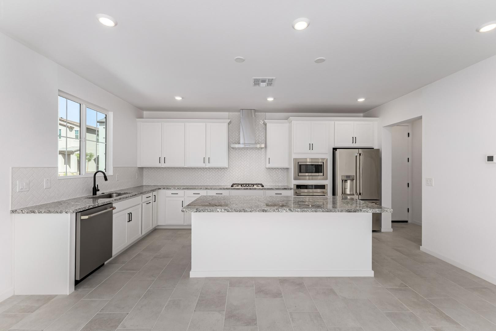 2436 West Maximo Way Phoenix, AZ 85085 - Photo 9 of 37 a large kitchen with stainless steel appliances kitchen island a large counter top and a stove top oven