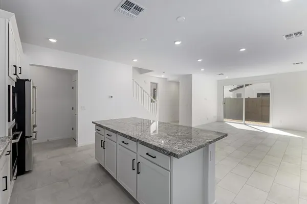a kitchen with stainless steel appliances granite countertop a sink and a refrigerator