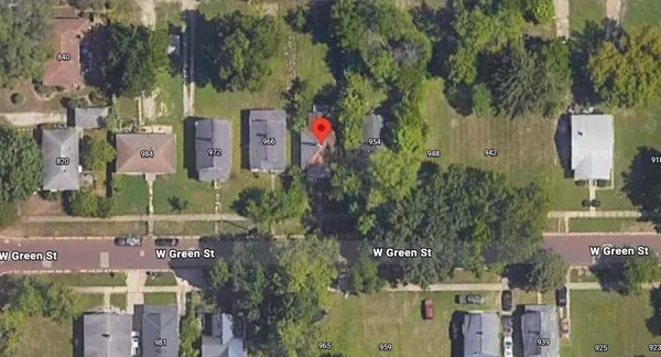 an aerial view of a house with a yard and large trees