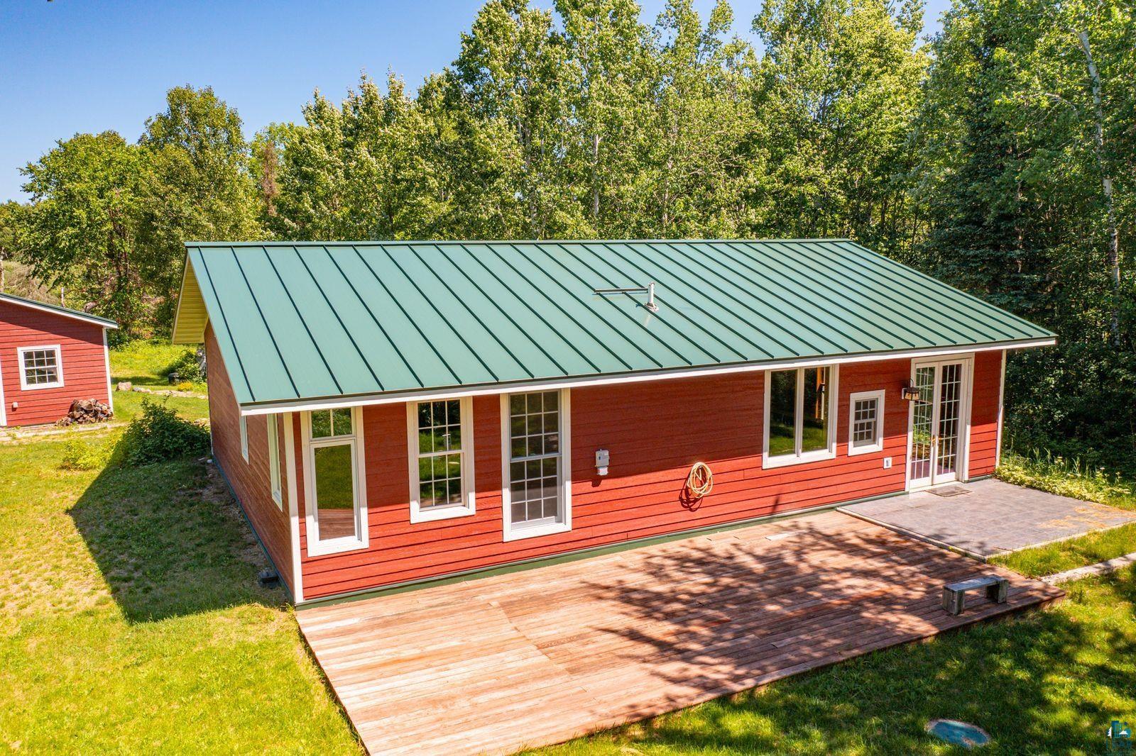 9734 Alango Road Angora, MN 55703 - Photo 24 of 41 Red-sided residence featuring a green metal roof and multiple large windows