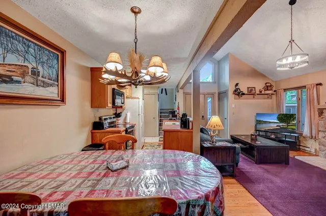 a room with furniture a flat screen tv and a refrigerator