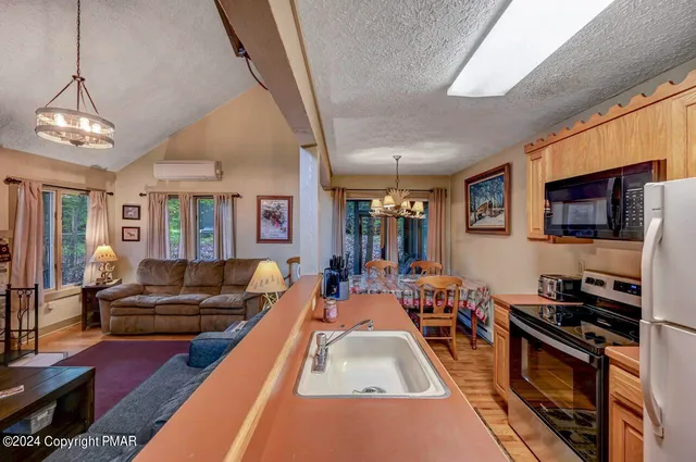 a living room with furniture a flat screen tv and a chandelier