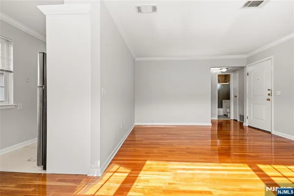 a view of empty room with wooden floor