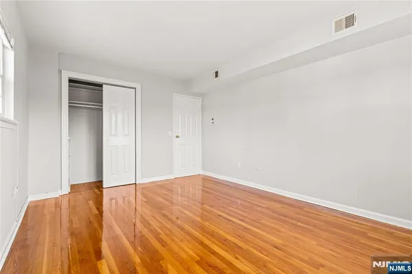 a view of empty room with wooden floor
