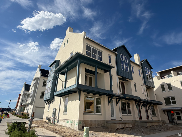 11021 South Freestone Road, Unit 121 South Jordan, UT 84009 - Photo 30 of 31 Multi-story residential facade featuring cream stucco and deep blue siding accents