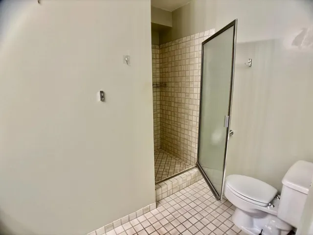 a bathroom with a granite countertop toilet and a shower