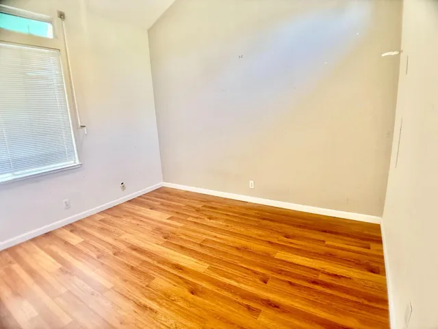 a view of empty room with wooden floor
