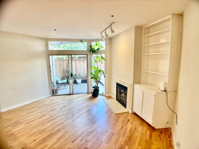 a view of an empty room with a fireplace and a window