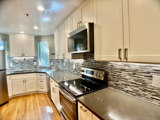 a kitchen with stainless steel appliances granite countertop a sink and a stove
