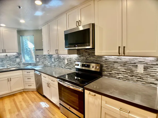 a kitchen with stainless steel appliances granite countertop a sink stove and microwave