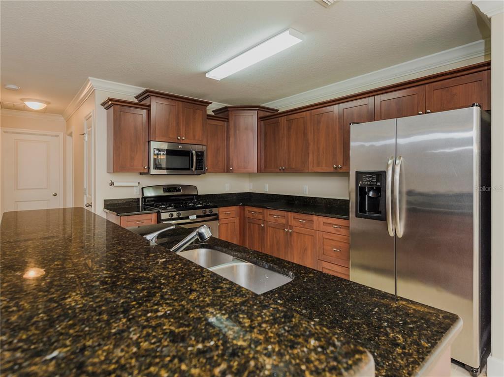 1642 Northwest 34th Avenue Gainesville, FL 32605 - Photo 4 of 14 a kitchen with granite countertop a refrigerator and a sink