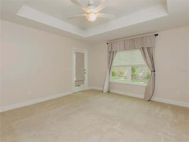an empty room with a window and a ceiling fan