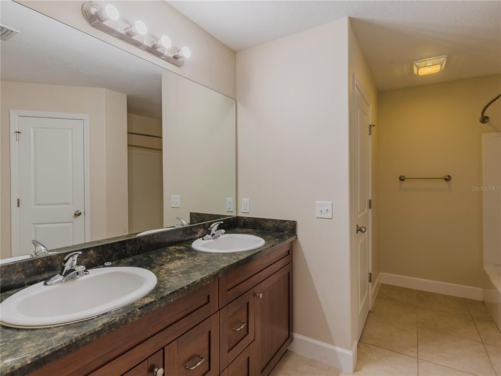 1642 Northwest 34th Avenue Gainesville, FL 32605 - Photo 7 of 14 a bathroom with a granite countertop sink and a mirror