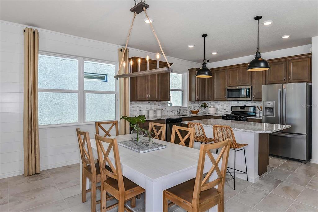 2364 Daisy Tree Road St. Cloud, FL 34771 - Photo 12 of 31 a kitchen with stainless steel appliances granite countertop a stove a refrigerator a kitchen island a sink and a refrigerator