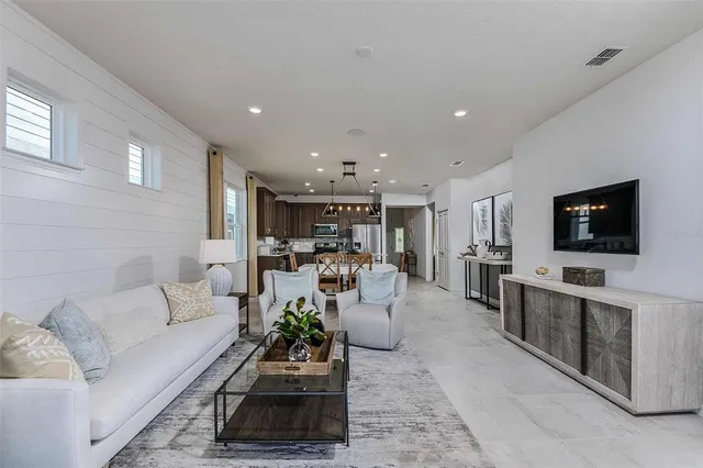 a living room with furniture and view of kitchen