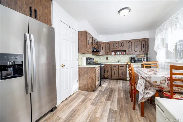 a kitchen with stainless steel appliances granite countertop a refrigerator a stove and a wooden floors